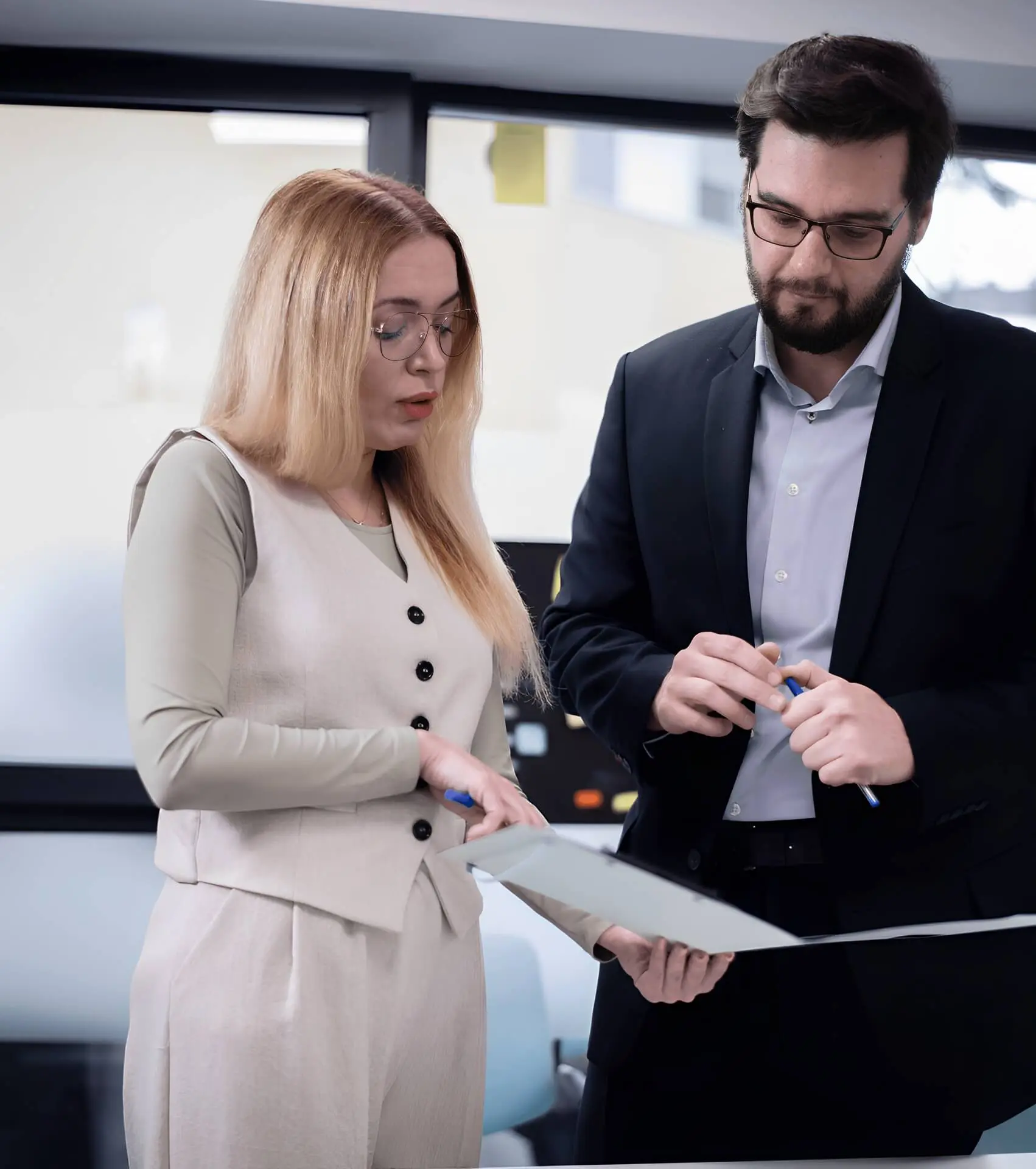 Two colleagues discussing documents in office.